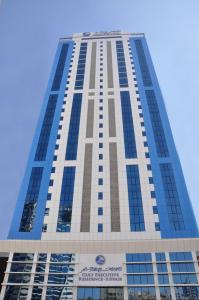 um edifício alto com um céu azul ao fundo em Gulf Executive Hotel & Residence Juffair em Manama