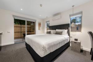 a hotel room with a large bed and a large window at Melbourne Airport Motel in Melbourne