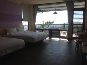 una camera d'albergo con due letti e un balcone di Legendary Bed and Breakfast a Fenchihu