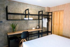 a bedroom with a bed and a desk and a chair at Sweed Dreams Hotel in Ko Lipe