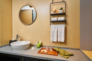 a bathroom with a sink and a mirror at Hotel Ease Access Tsuen Wan in Hong Kong