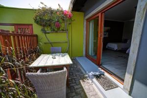a small patio with a wooden table and a window at Organic Stay Guesthouse in Swakopmund