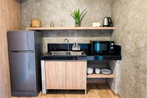 a kitchen with a sink and a microwave at Sweed Dreams Hotel in Ko Lipe