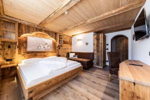 1 dormitorio con cama y escritorio en Garni Hotel Residence Diamant en San Vigilio Di Marebbe
