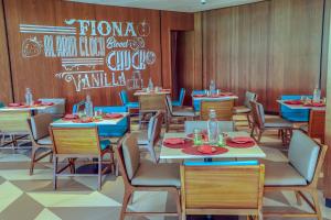 a dining room with tables and chairs and a chalkboard at Hard Rock Hotel Desaru Coast in Desaru