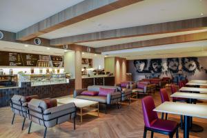 a restaurant with couches and tables and chairs at Hard Rock Hotel Desaru Coast in Desaru