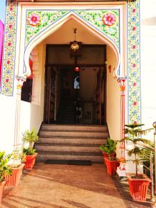 an entrance to a building with stairs and flowers at Kalyan Heritage in Jaipur