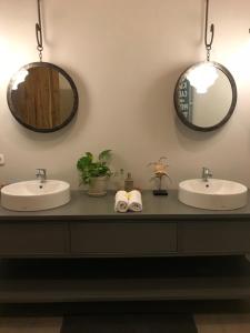 two sinks in a bathroom with two mirrors at Seabirds Bed and Breakfast in Jepara
