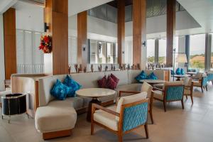 a lobby with chairs and tables and blue pillows at Hard Rock Hotel Desaru Coast in Desaru