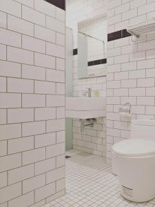 een witte badkamer met een toilet en een wastafel bij Ob Ba in Hualien