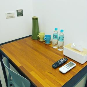 a table with a remote control and two bottles of water at Ob Ba in Hualien City