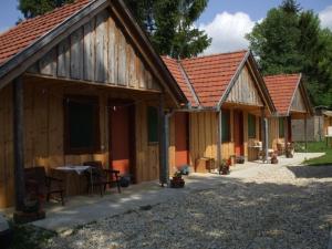 a couple of wooden buildings with a table in front at Fazekas Vendégház és Kemping in Őriszentpéter