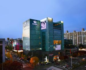Un edificio alto con un cartel en una ciudad. en Daegu AW Hotel, en Daegu