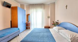 een slaapkamer met 2 bedden en een raam bij Hotel Roby in Riccione