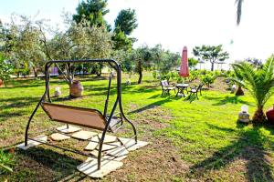 a park with a swing in the grass at Pelagos Beachfront in Panormos Skopelos