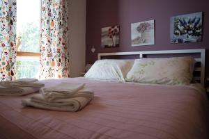 a bed with towels on top of it with a window at B&B Villa Noemi in Formia