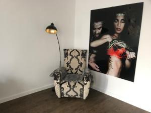 une chaise et une lampe dans une pièce avec photo dans l'établissement Ferien Apartment, à Brême