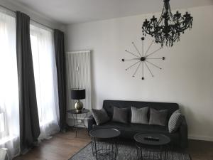 a living room with a black couch and a clock on the wall at Ferien Apartment in Bremen