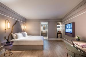 成都Chengdu Taikoo Li Chunxi Mercure Hotel的一间卧室，里面有一张床和一台平板电视