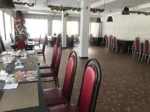 a dining room with tables and chairs in a restaurant at Nuri Hotel Стадион in Karagandy