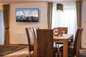a dining room with a table and chairs and mountains at Kaiser Chalet in Going