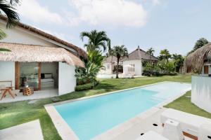 a villa with a swimming pool and a resort at The Apartments Umalas in Canggu