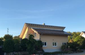 ein Haus mit Sonnenkollektoren auf dem Dach in der Unterkunft Souterrain Ferienwohnung im Acherner Weg in Achern