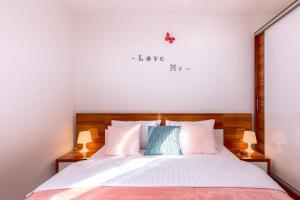 a bedroom with a bed with alove me sign on the wall at Apartments Lulic in Crikvenica