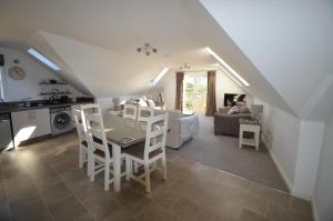 a kitchen and living room with a table and chairs at Riverbank Apartments in Nairn