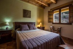 1 dormitorio con 1 cama, 2 sillas y ventana en Casas Rurales El Nacimiento en Pontones