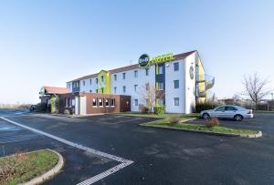 a car parked in a parking lot in front of a hotel at B&B HOTEL CHATEAUROUX Déols in Déols
