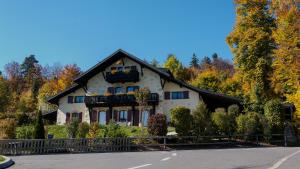 a white house with a black roof at BnB La Clemonie in Arzier