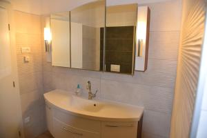 een witte badkamer met een wastafel en een spiegel bij Villa Pina Tisno in Tisno +16 foto's