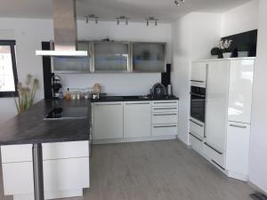 een keuken met witte kasten en een zwart aanrechtblad bij Villa Pina Tisno in Tisno