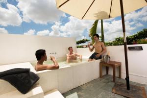 three men are sitting in a bath tub at Rambutan Resort &ndash; Phnom Penh in Phnom Penh