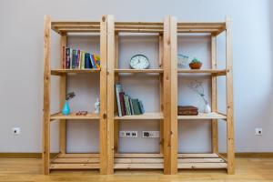 a wooden book shelf with a clock on it at Light and spacious Apartment on Gazova Str in Lviv