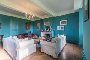 a living room with blue walls and white furniture at Château de Maumusson in Maumusson-Laguian