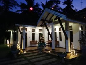 un albero di Natale di fronte a una casa di notte di Sayo Villa a Negombo