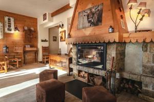 a living room with a fireplace and a dining room at L'Alpage in Le Grand-Bornand