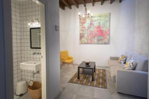 salon z kanapą i umywalką w obiekcie Casas de Sevilla - Casa Sevillana Harinas26 w Sewilli