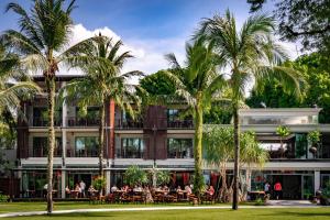 un hôtel avec des palmiers devant lui dans l'établissement Ramada Resort by Wyndham Khao Lak, à Khao Lak