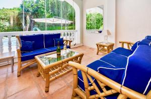 a living room with blue couches and a glass table at Villa Melissa by Rafleys in Marbella