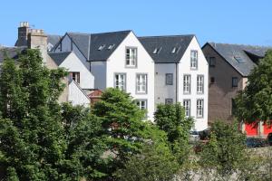 a row of white houses with black roofs at Riverbank Apartments in Nairn