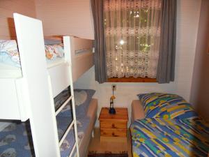 Schlafsaal mit 2 Etagenbetten und einem Fenster in der Unterkunft Ferienhaus von Bargen in Cuxhaven