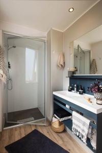 La salle de bains est pourvue d'une douche en verre et d'un lavabo. dans l'établissement Carazur Mobilhomes Camping Fréjus, à Fréjus