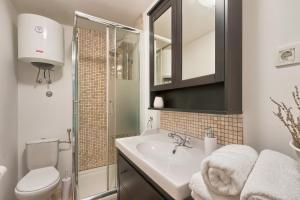 羅維尼的住宿－Davor holiday apartments，一间带水槽、卫生间和镜子的浴室