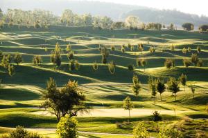 - Vistas a un campo de golf con árboles y césped en Hotel Kaskáda en Kuřim