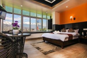 Un dormitorio con una cama y una mesa y ventanas. en Hotel Lakeside Pvt. Ltd., en Pokhara