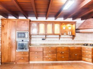 a kitchen with wooden cabinets and a stove at LAS MORADITAS, CHALET con PISCINA PRIVADA in Adeje
