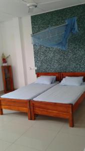 dos camas sentadas una al lado de la otra en una habitación en Masha Beach Inn, en Tangalle